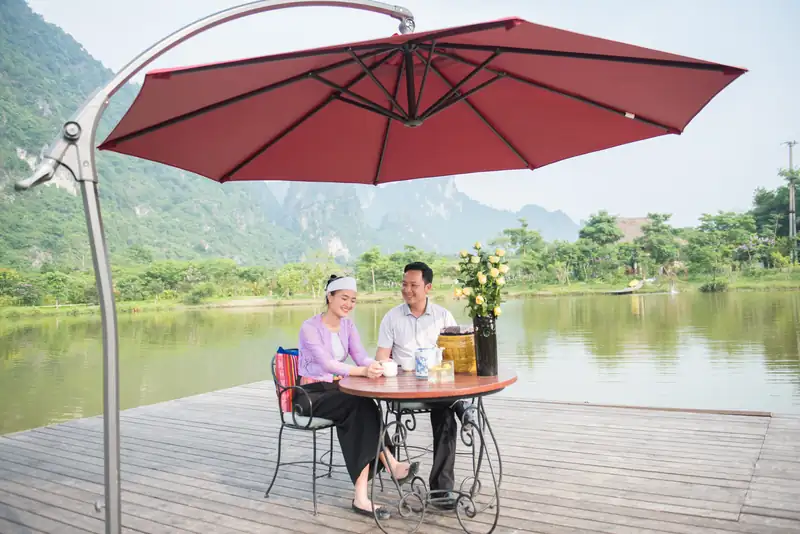 Cặp đôi dùng bữa bên hồ dưới ô đỏ ở Serena Kim Bôi