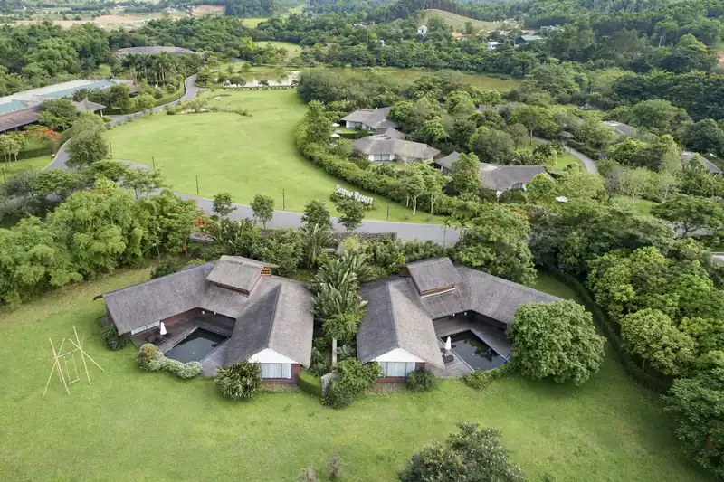 Các villa mái tranh giữa bãi cỏ và vườn cây ở Serena Resort Kim Bôi nhìn từ trên cao