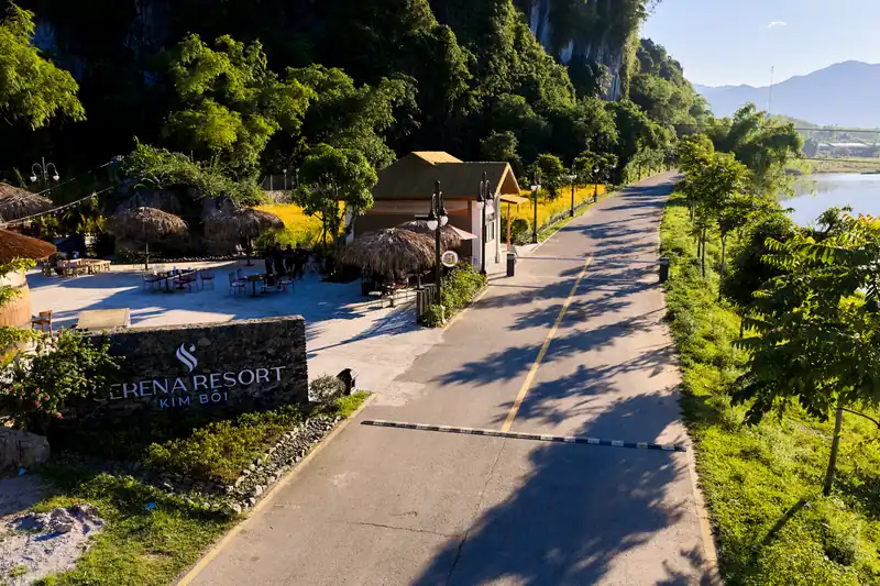 Biển tên Serena Resort Kim Bôi bên con đường nhựa dẫn vào khu, núi đá vôi phía sau, nhìn từ trên cao