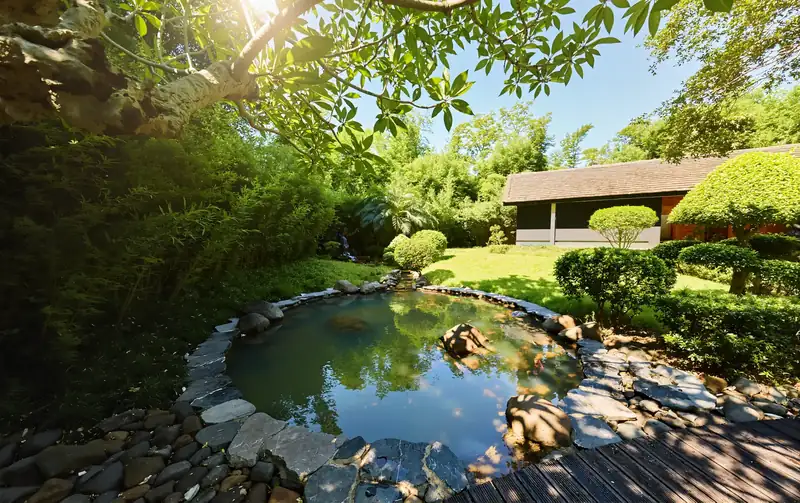 Bể onsen hình tròn lát đá giữa vườn cây ở Serena Kim Bôi