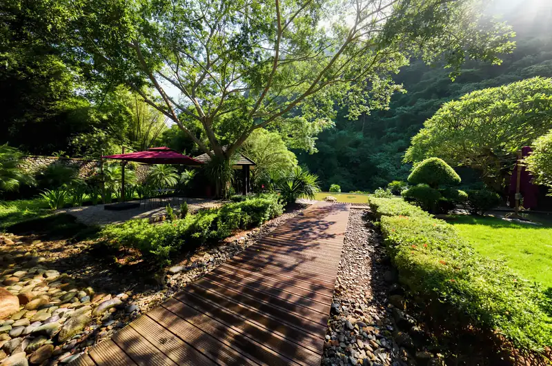 Lối đi lát gỗ dẫn vào khu Onsen kiểu Nhật giữa vườn cây ở Serena Kim Bôi