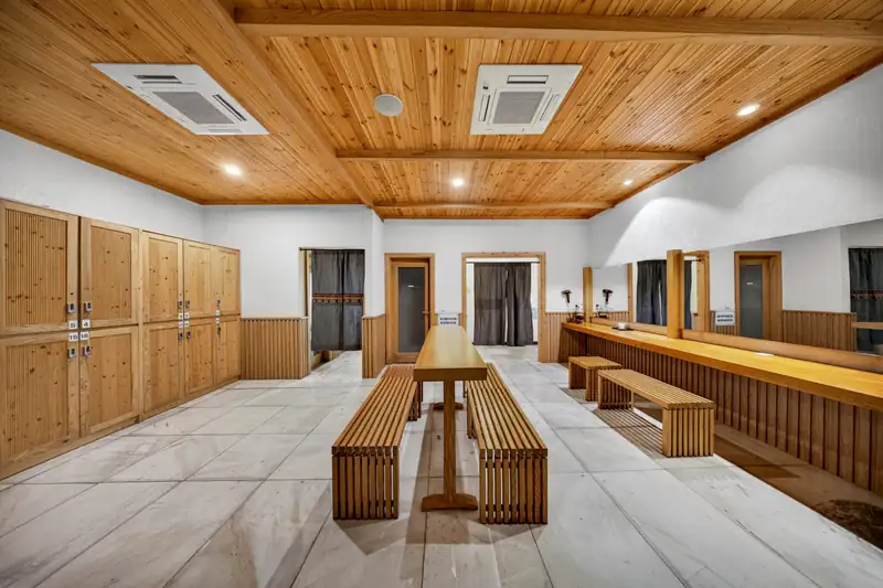 Phòng thay đồ ốp gỗ có tủ và ghế dài ở khu Onsen Serena Kim Bôi