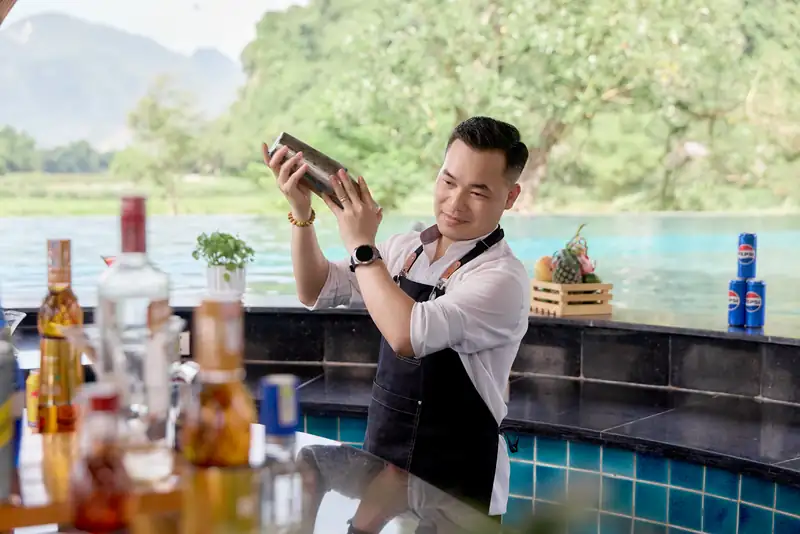 Nhân viên pha đồ uống ở quầy bar cạnh hồ bơi ngoài trời Serena Kim Bôi