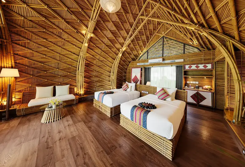 Bungalow hai giường đơn dưới vòm tre hình bông sen, góc sofa cạnh cửa kính