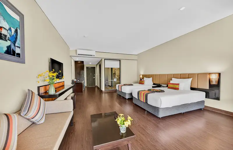 Phòng Deluxe Nature View hai giường đơn, sofa dài và bàn trà ở Serena Kim Bôi