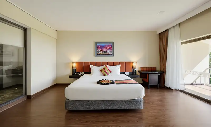 Phòng Deluxe Nature View giường đôi, cửa kính lớn và rèm vải ở Serena Kim Bôi