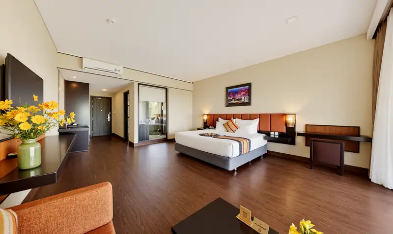 Phòng Deluxe Nature View giường đôi nhìn từ góc phòng, sàn gỗ và bàn làm việc