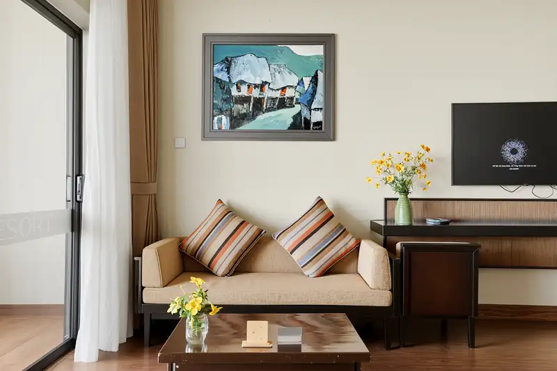 Góc sofa, bàn trà và bàn làm việc trong phòng Deluxe Nature View ở Serena Kim Bôi
