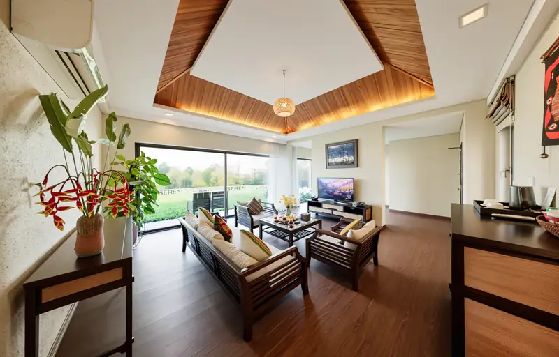 Phòng khách Garden Villa trần gỗ, sofa và cửa kính nhìn ra vườn