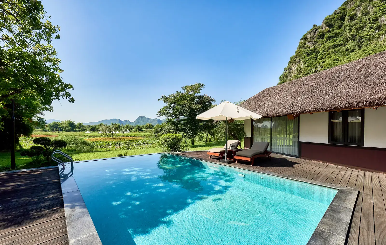 Hồ bơi riêng của Onsen Villa, ô che nắng và núi đá vôi phía sau