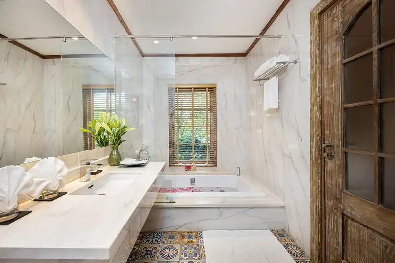 Phòng tắm Osaka Hill có bàn đá dài, bồn Jacuzzi và sàn gạch hoa văn