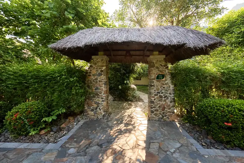 Cổng mái tranh trụ đá trên lối đi lát đá ở khu Zen Suite