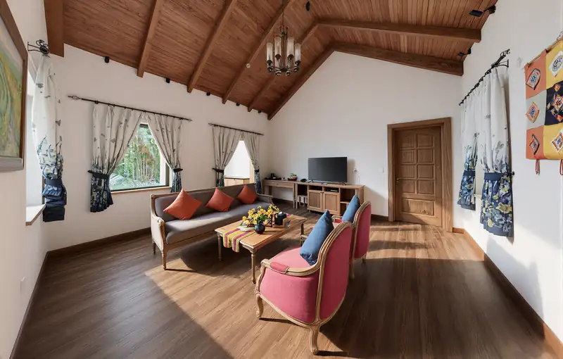 Phòng khách Zen Suite trần gỗ, sofa và ghế bành đỏ
