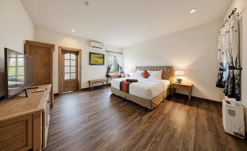 Phòng ngủ Zen Suite nhìn từ góc phòng, sàn gỗ và cửa ra hiên